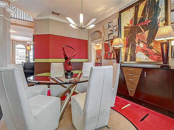 The formal dining room is open to the main entry and steps away from the family room and through the arched opening on the right to the kitchen area. This room boasts beautiful dark flooring and deep crown molding. Notice the fabulous designer chande