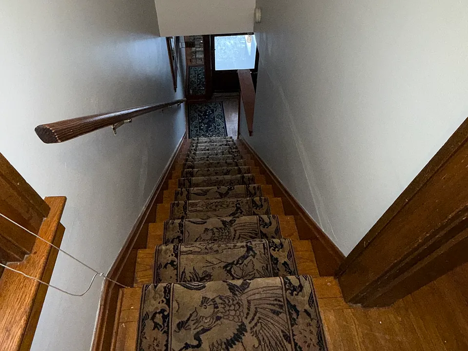 View from apartment entry looking down at stairway and front door of unit