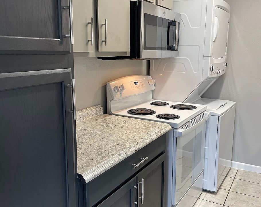 Galley kitchen features new countertops and full-sized stackable washer/dryer.