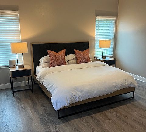 Spacious primary suite with double doors leading directly to the screened patio, creating a peaceful retreat just steps from the outdoors. The room accommodates a king bed comfortably and includes a large walk-in closet.