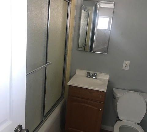 Spacious full bathroom w laminate wood floors