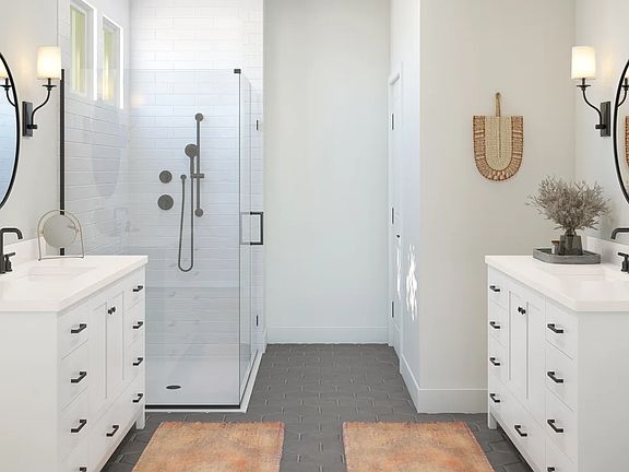 Primary bath with dual vanities and glass shower enclosure
