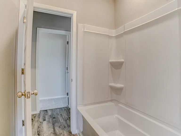View from inside the full bathroom that separates the bedrooms. View to the left is the door to bedroom #2 and access to the living room.