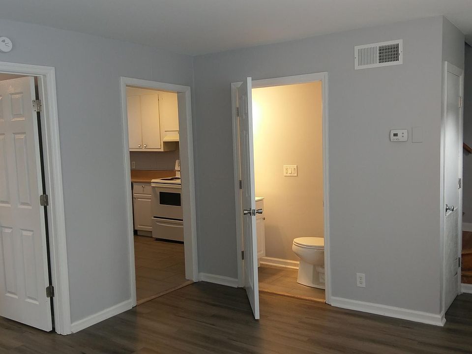 Living room with views of office (left door), kitchen and half bath