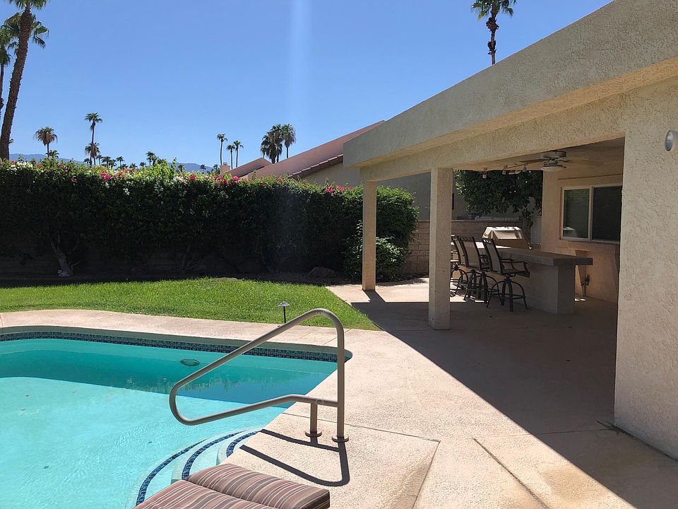 Large private backyard with sparkling pool, covered patio, gas bbq, and bar with seating.