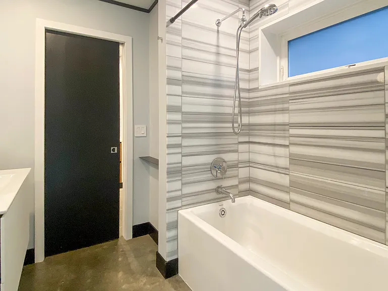 Marble tiled bathroom with shower/tub, vanity, built-in storage