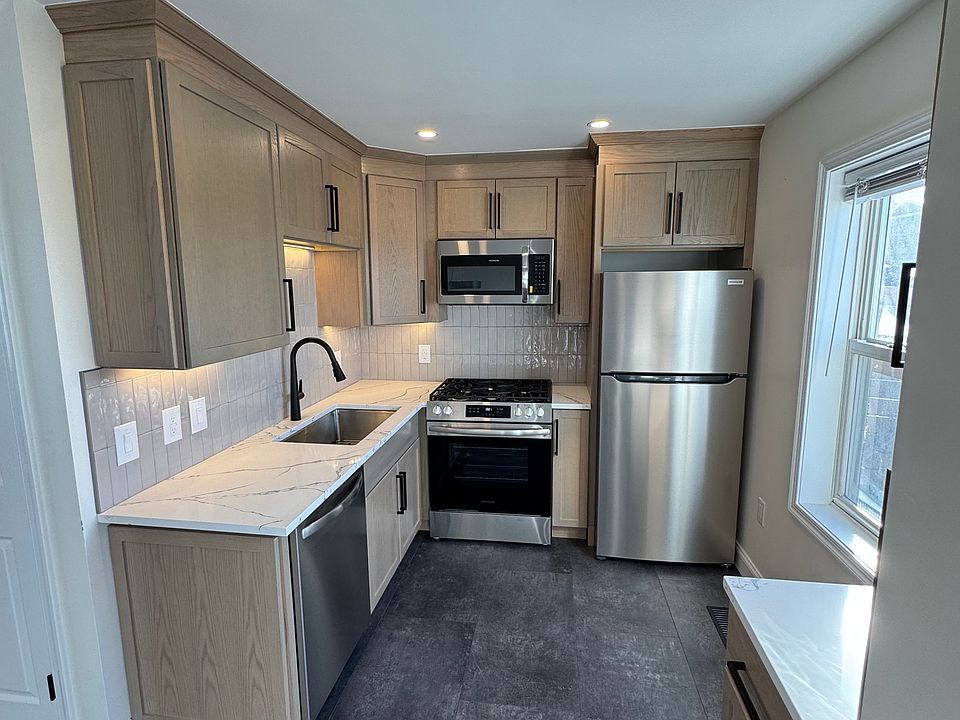 Brand new kitchen with quartz counters, large sink, under cabinet lighting and new appliances.