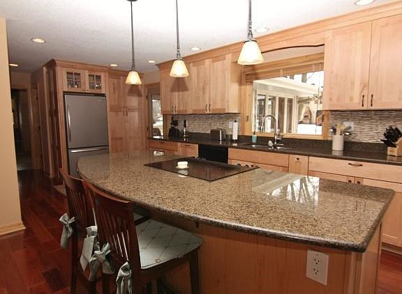 The kitchen features maple cabinets with soft close drawers, roll out trash and spice racks, vaulted ceiling and pendant lights make the kitchen open and airy!