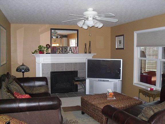 Family room with gas fireplace, ceiling fan, and walkout to addition