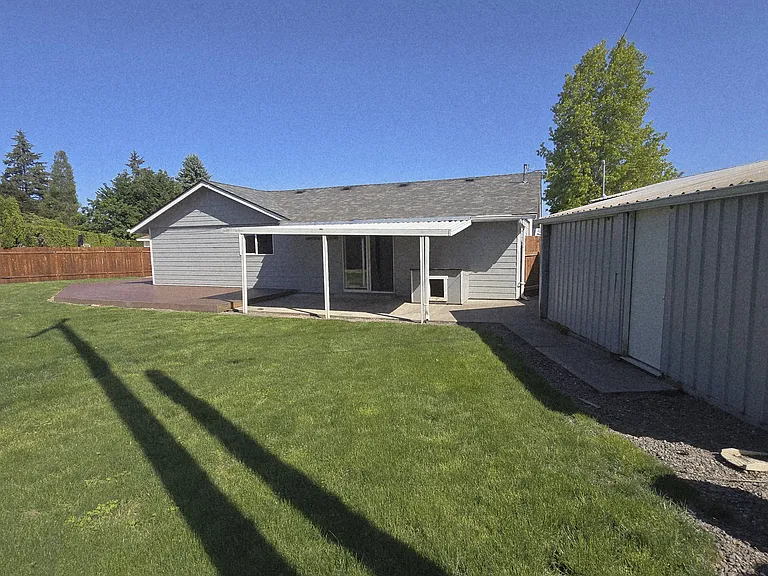 Backyard off private suite; covered patio and side entrance to detached shop.