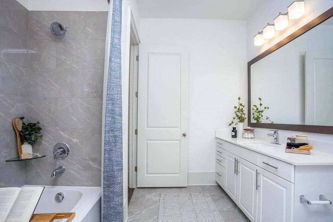 Bathroom Featuring Tile Shower Wall and Extended Countertop with Sink