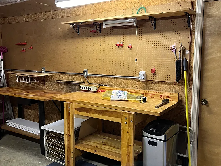 Two work benches with pegboard to mount tools.