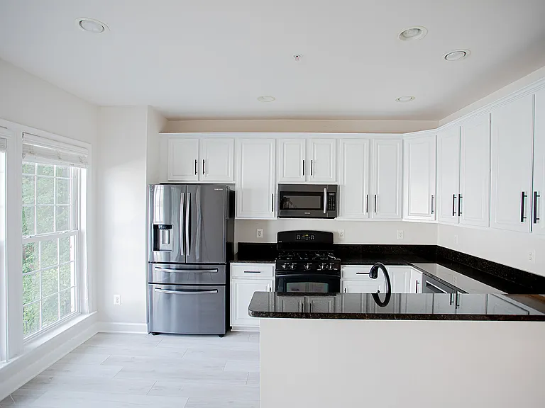 Modern Sleek Kitchen featuring granite countertops and updated stainless steel appliances. Gas stove and functional fridge