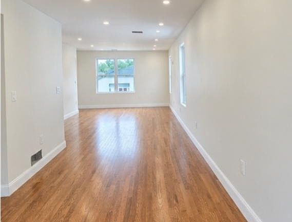 Spacious Living Room with Recessed Lighting and Beautiful Hardwood Floors.