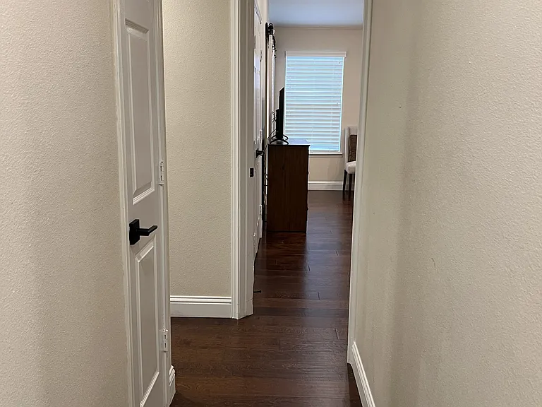 Hardwood-lined hallway leading to spacious private bedrooms and living quarters.