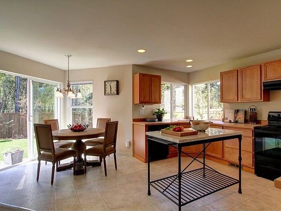 Surrounded by natural light, this breakfast nook is the perfect place to sit and enjoy a cup of coffee in the morning.  The sliding doors lead to a concrete patio, the perfect place for a summer barbeque.  