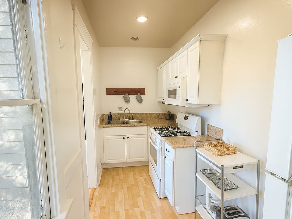 Full kitchen with gas range, ample cabinet space, and window light.