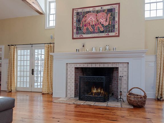 The large fireplace with a dramatic surround takes center stage in the Great Room. French doors open to a covered patio with a fireplace and pizza oven.