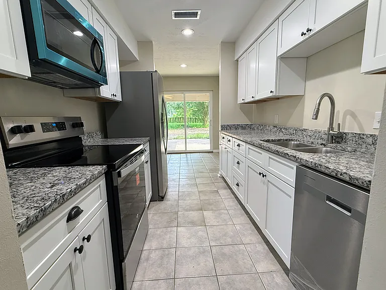 Functional galley-style kitchen with new appliances, cabinets and easy access to the main living areas