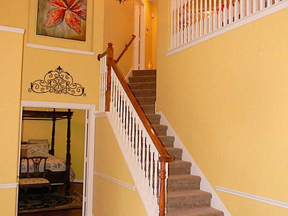 Entry way features warm colors, high ceilings and large tiles.