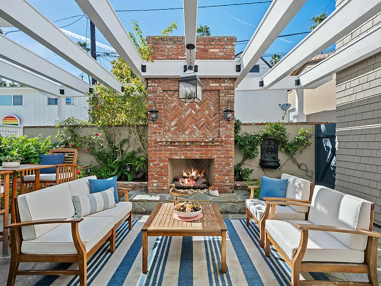 Secure and private backyard with beautiful brick fireplace, water feature, professional BBQ and arbor