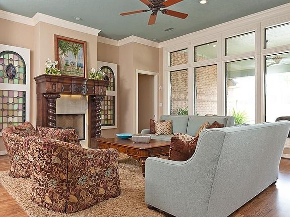 This home has a custom feel throughout. The family room is accented by a wall of windows looking out onto pool area.