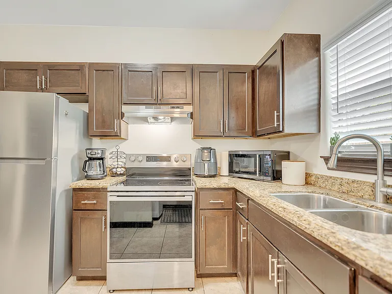 Contemporary kitchen showcasing stainless steel appliances and granite countertops at La Joya Apartments in Laredo, Texas