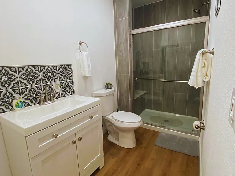 Immaculate bathroom with shower, essentials and fresh bath mats.