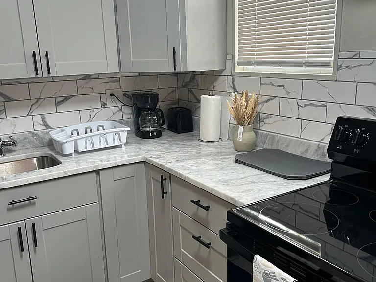 Updated kitchen with ample shaker cabinetry, generous counter space, and a smooth-top range for everyday cooking.