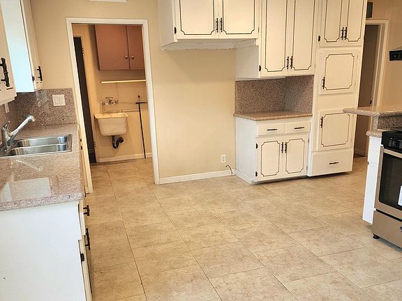 View of spacious kitchen cabinets and refrigerator area.
