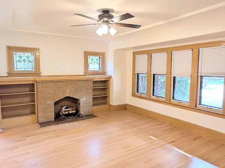 Living room. Non-functional fireplace has outlet for plug in. Refinished hardwood floors and built in shelves