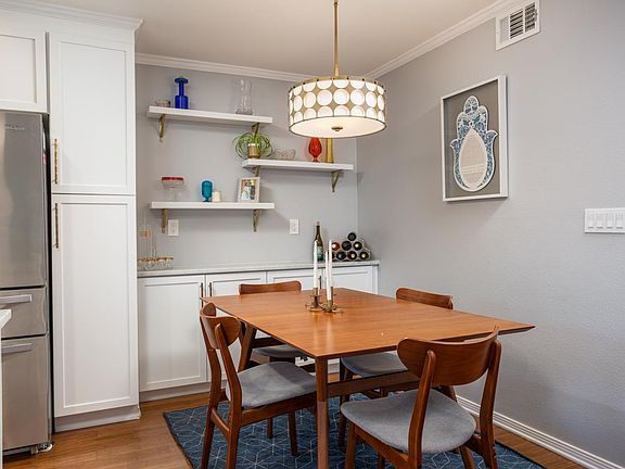 Cozy dining area with art deco lighting and built-in sideboard for extra storage!