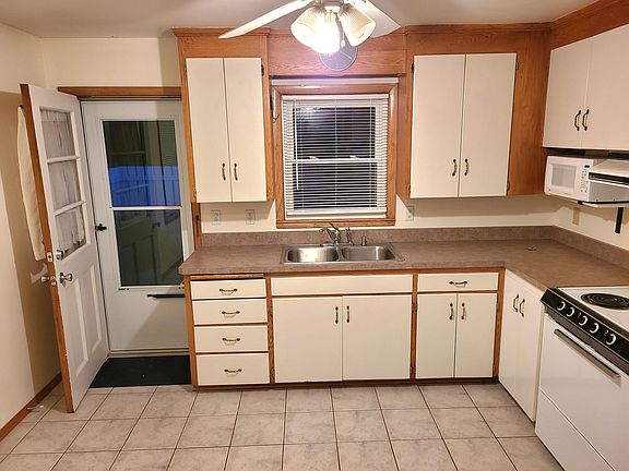 Clean kitchen with a microwave. The door leads to the patio.