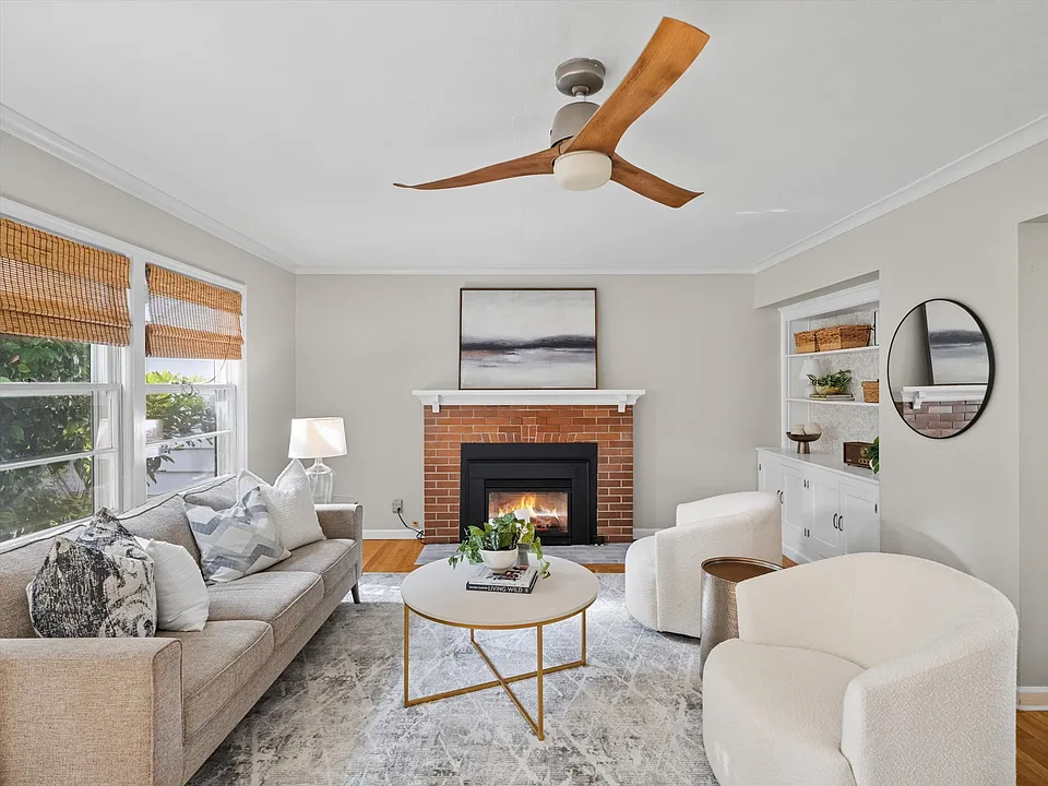 The spacious living room full of natural light and is perfect for entertaining or relaxing around the gas fireplace.