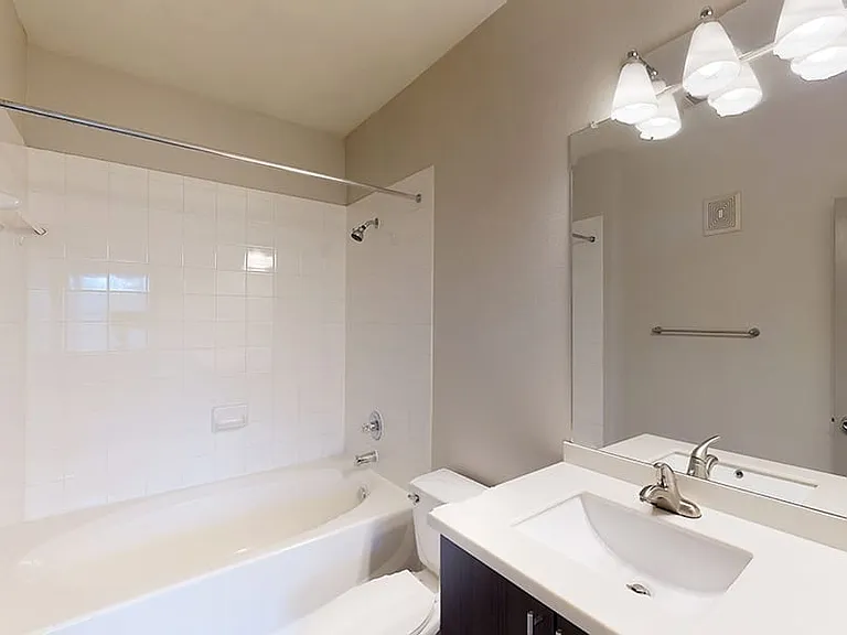 Apartment bathroom with large soaking tub and wood-style flooring.