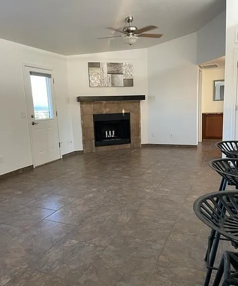 Living room with vaulted ceiling, 2 fans, fireplace and door with security screen to backyard offering amazing cross breeze