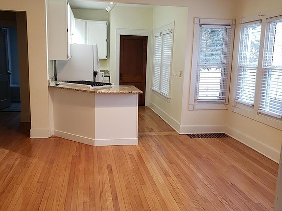 Beautiful hardwood floors in bright kitchen, dining room, and hall