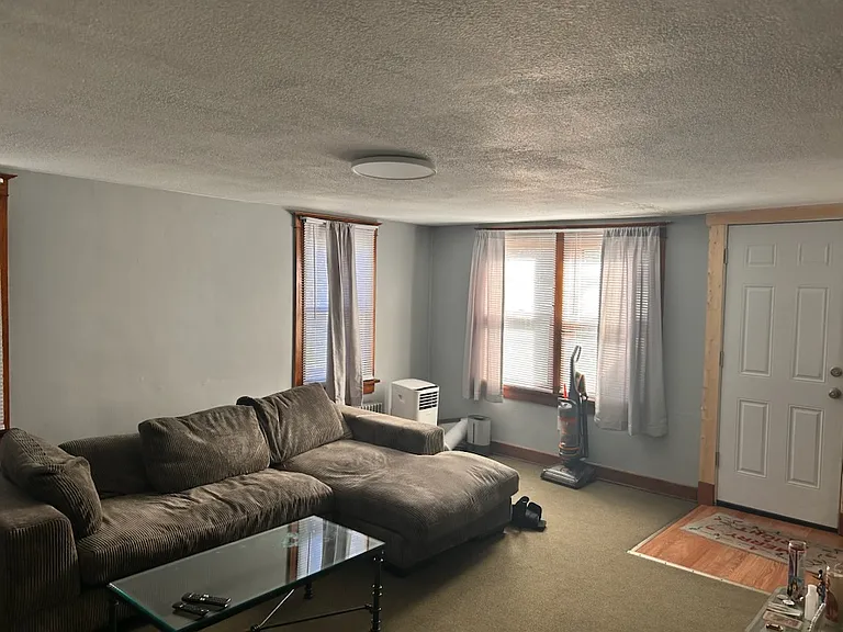 Large Living room unfurnished or furnished with balcony and brand new insulated door leading to it.