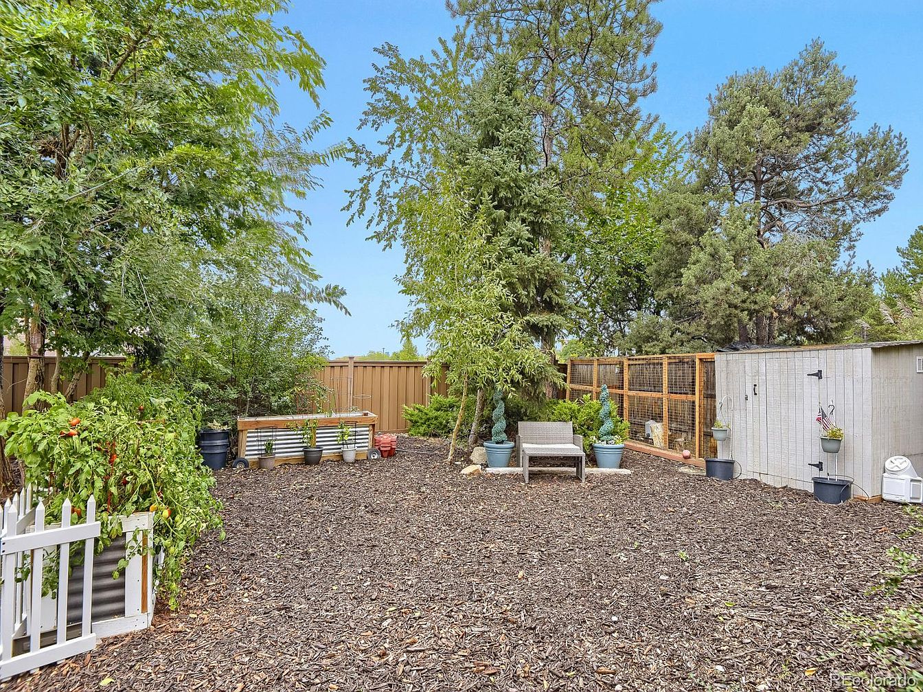 Private fenced backyard with mature trees and garden space