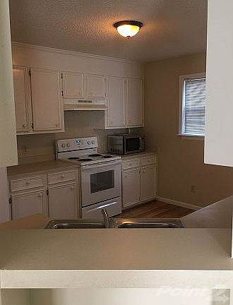 Spacious kitchen with white cabinets and HW's