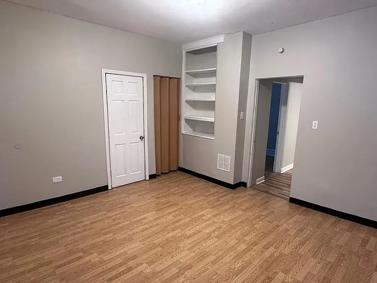 Spacious primary bedroom with built-in shelving