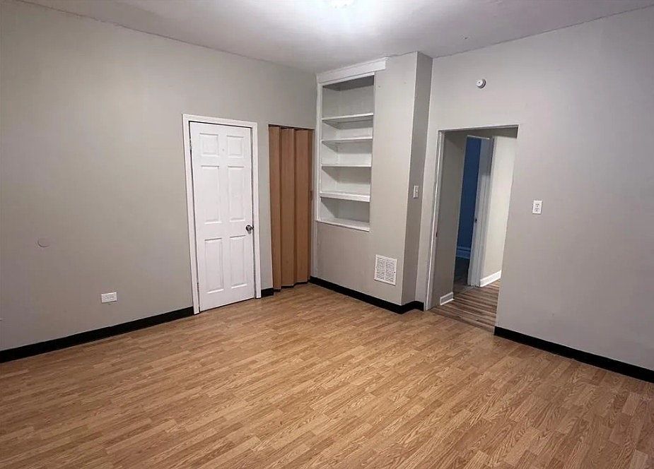Spacious primary bedroom with built-in shelving