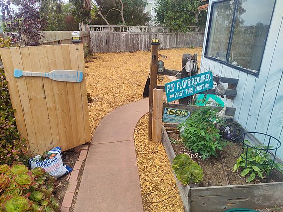 pathway leading to front door of the apartment with a small planter box