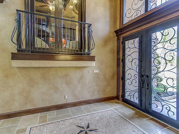 Main entry with double wrought iron doors and custom insert