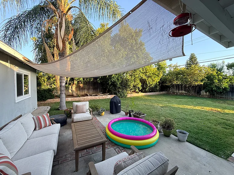 Backyard patio with shade and furniture