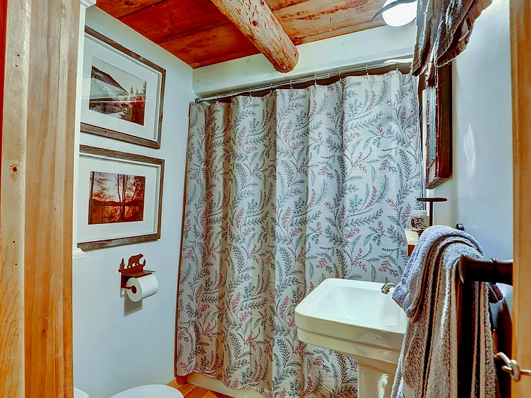 Full Bathroom with tub shower and sink with towel racks.