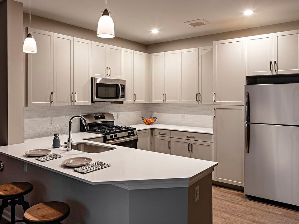 Modern kitchens with grey cabinetry, white quartz countertops, tile backsplash, stainless steel appliances, and hard surface flooring