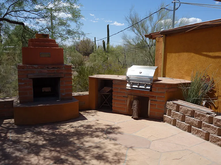 Outdoor fireplace and gas grill off front patio.