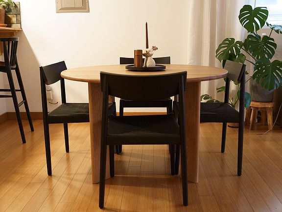 Dining area with ceiling fan & light above the table. There is a food bar to the left side of the picture that flows into the kitchen.