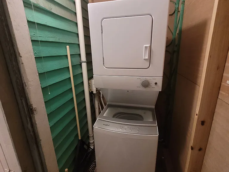 Laundry room with stacked washer/dryer at the end of the hall by the kitchen